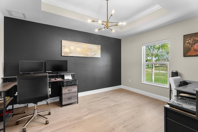 office space with an inviting chandelier, light wood-type flooring, crown molding, and a tray ceiling