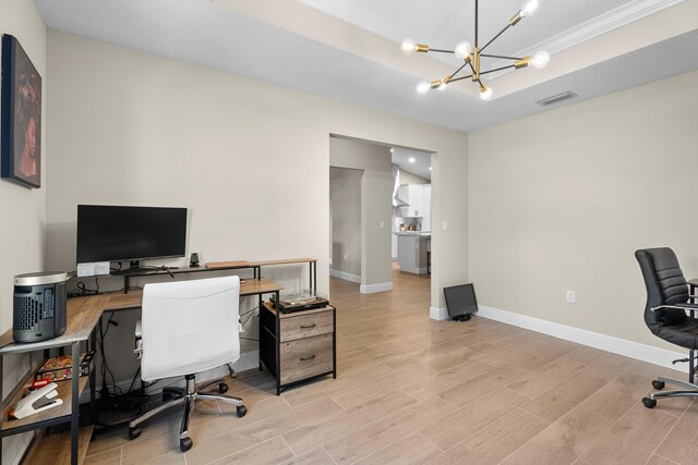 office space with a tray ceiling and an inviting chandelier