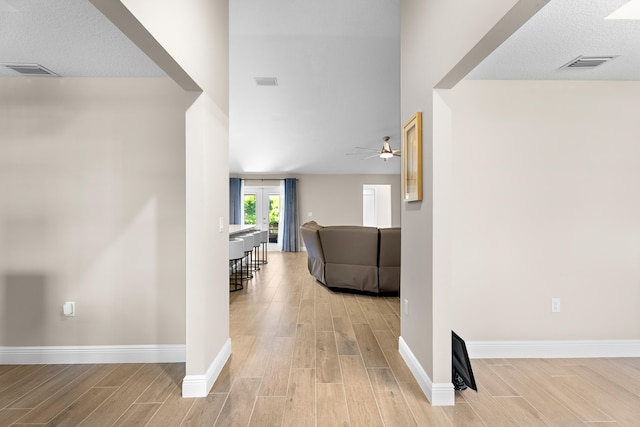 hallway featuring french doors and light wood-type flooring