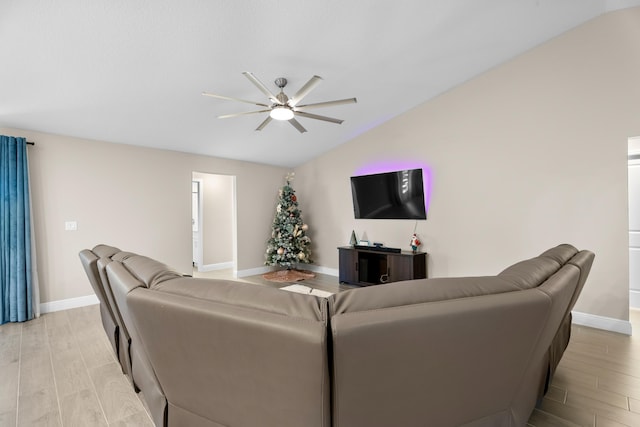 living room with ceiling fan, vaulted ceiling, and light hardwood / wood-style flooring