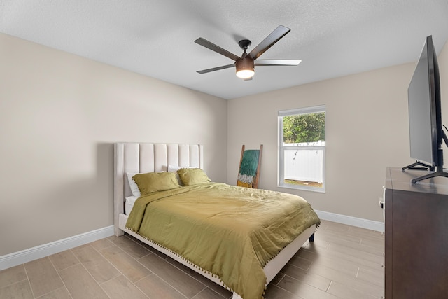 bedroom with ceiling fan and a textured ceiling