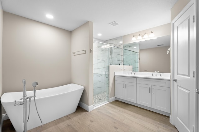 bathroom featuring hardwood / wood-style floors, vanity, and shower with separate bathtub