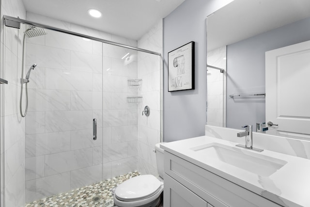 bathroom with an enclosed shower, vanity, and toilet