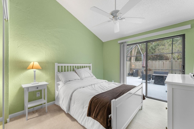 bedroom featuring ceiling fan, light colored carpet, access to exterior, vaulted ceiling, and a textured ceiling