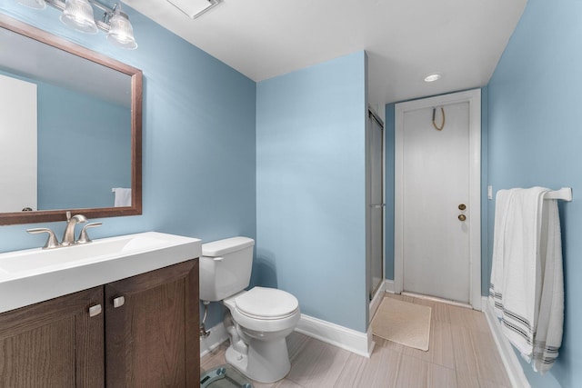 bathroom with toilet, vanity, and an enclosed shower