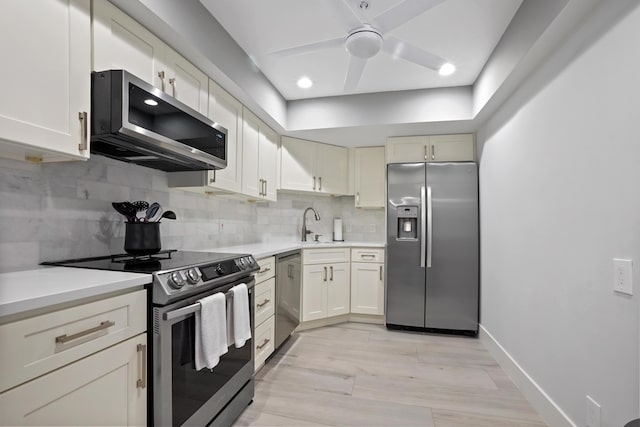 kitchen with backsplash, ceiling fan, sink, and stainless steel appliances