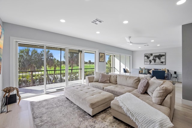 living room featuring ceiling fan and light hardwood / wood-style flooring