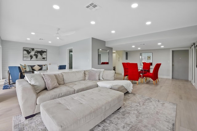 living room featuring light wood-type flooring and ceiling fan