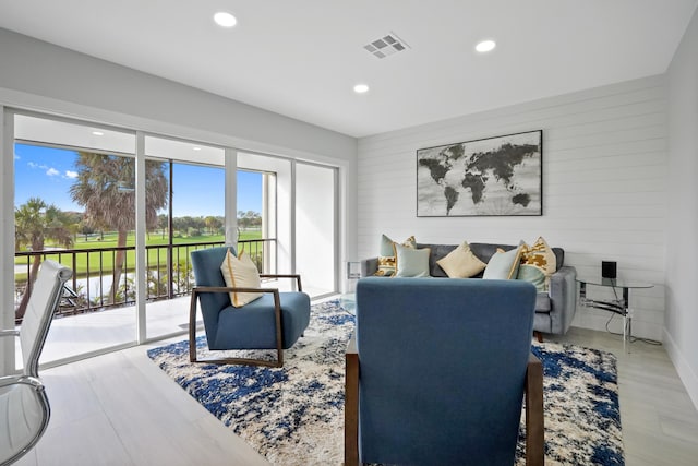 living room with hardwood / wood-style flooring and wooden walls