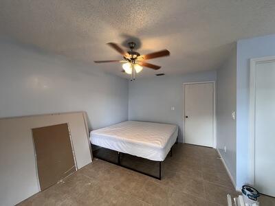 unfurnished bedroom with ceiling fan and a textured ceiling