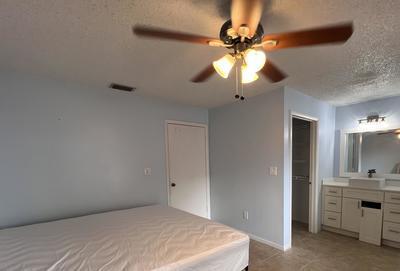 unfurnished bedroom with a textured ceiling, ceiling fan, and sink