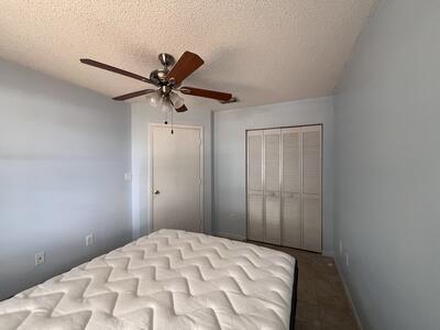 unfurnished bedroom with a textured ceiling, a closet, and ceiling fan