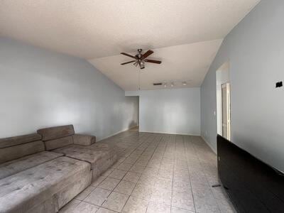 unfurnished living room featuring ceiling fan and lofted ceiling