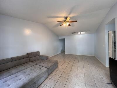 living room with ceiling fan and lofted ceiling