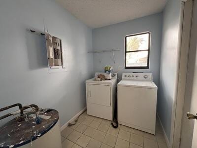 washroom featuring electric panel, washer and clothes dryer, and a textured ceiling