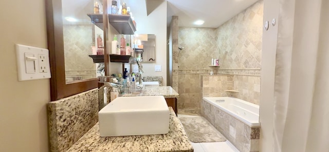 bathroom featuring tile patterned floors, a relaxing tiled tub, sink, and tile walls