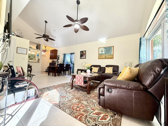 living room with ceiling fan, light tile patterned floors, and vaulted ceiling