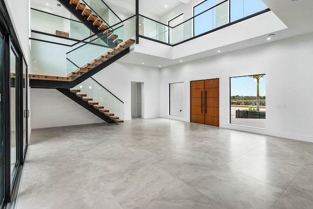 unfurnished living room with a high ceiling