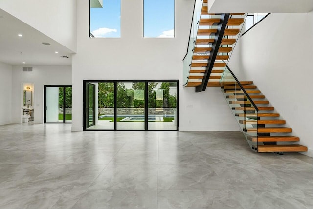 unfurnished living room with a towering ceiling