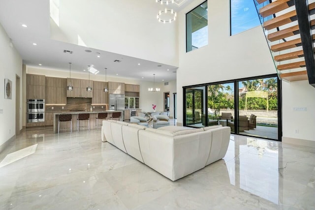 unfurnished living room with a high ceiling and an inviting chandelier