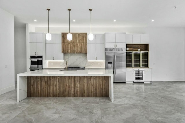 kitchen featuring white cabinets, wine cooler, a center island with sink, and appliances with stainless steel finishes