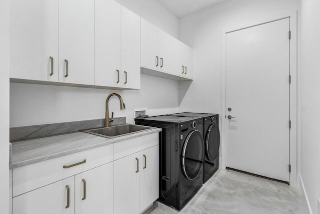 washroom featuring cabinets, sink, and washing machine and clothes dryer