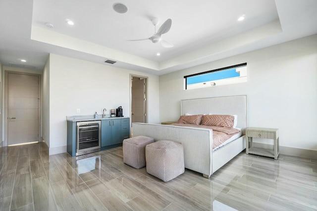 bedroom featuring a raised ceiling, wine cooler, and ceiling fan