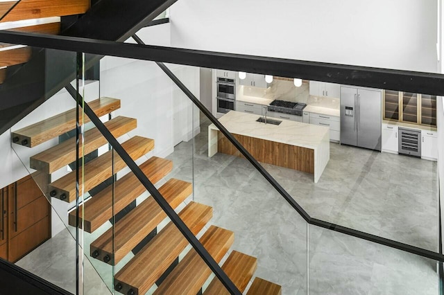 staircase featuring wine cooler and sink