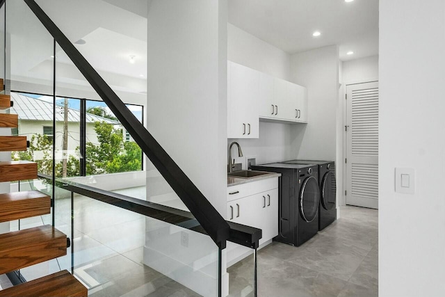 interior space with washer and dryer, white cabinets, and sink