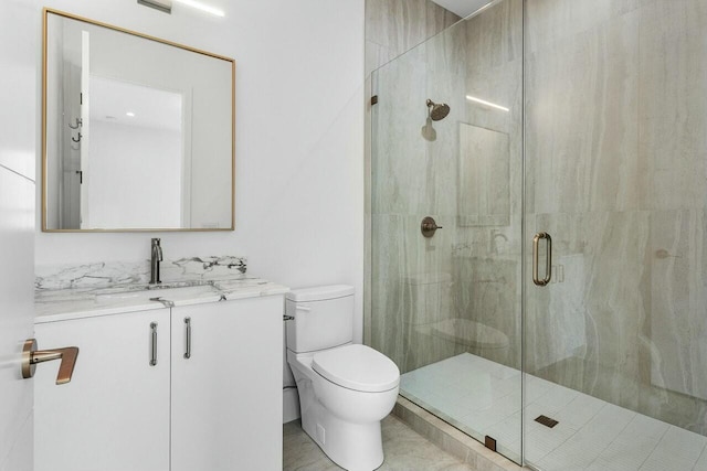 bathroom featuring vanity, toilet, and a shower with shower door