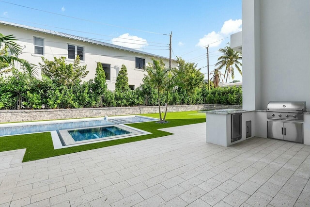 view of swimming pool with an in ground hot tub, an outdoor kitchen, area for grilling, and a patio area