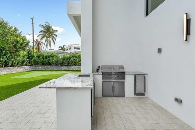 view of patio with an outdoor kitchen and a grill