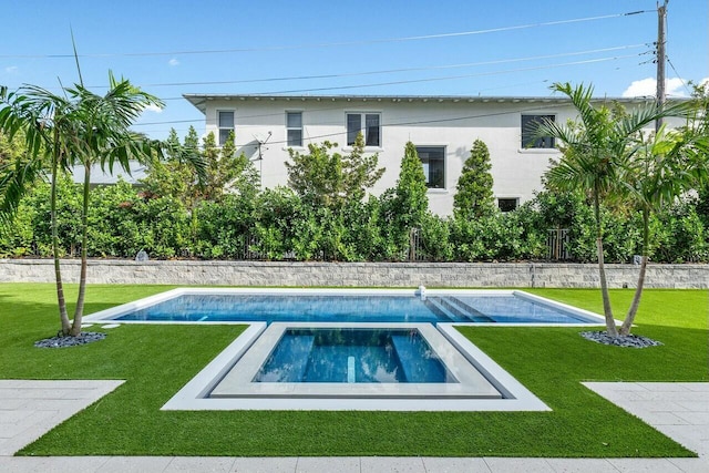 view of swimming pool featuring a lawn and an in ground hot tub