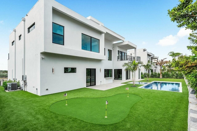 back of house with a lawn, central AC, a balcony, and a patio