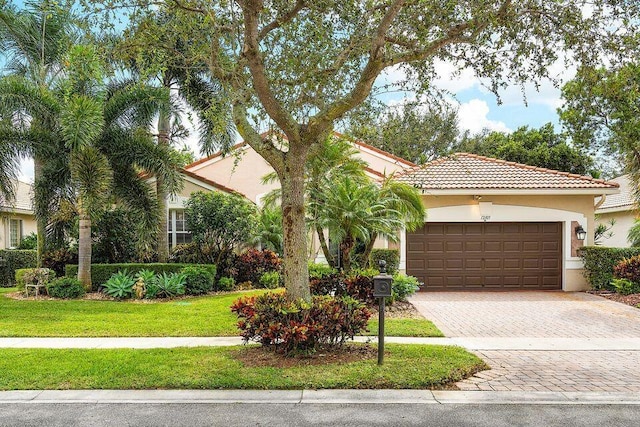 mediterranean / spanish home with a front yard and a garage