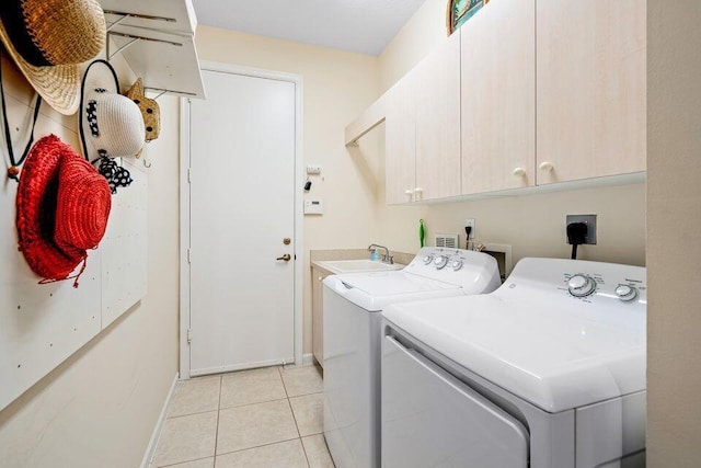 laundry area featuring cabinets, independent washer and dryer, light tile patterned flooring, and sink