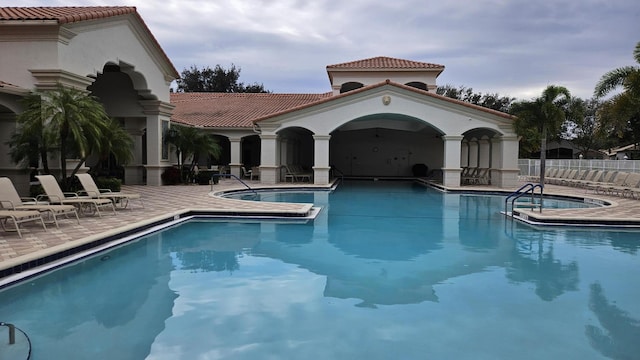 view of swimming pool with a patio and a hot tub