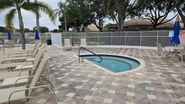 view of pool with a hot tub and a patio area