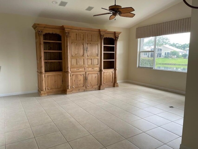 empty room featuring ceiling fan, light tile patterned floors, and vaulted ceiling