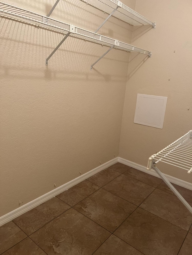 walk in closet with dark tile patterned floors