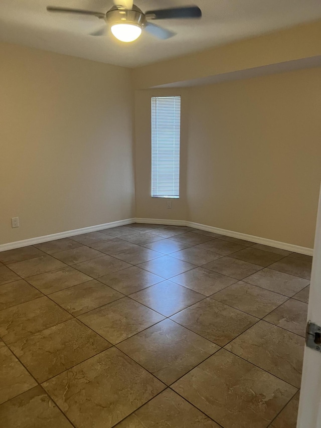 tiled spare room featuring ceiling fan