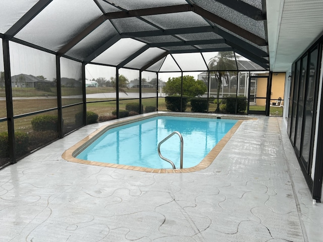 view of pool featuring glass enclosure and a patio