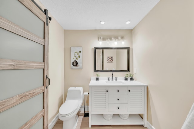 bathroom featuring vanity, toilet, and a textured ceiling