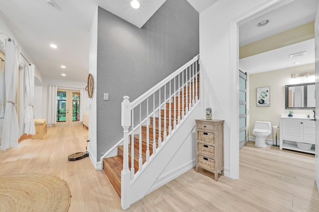 staircase with hardwood / wood-style floors and french doors