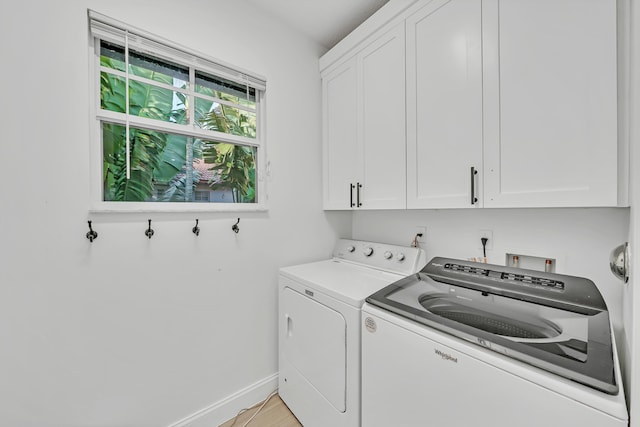 laundry room featuring cabinets and washer and clothes dryer