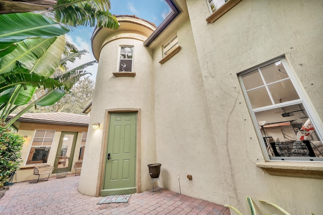 view of exterior entry with a patio area