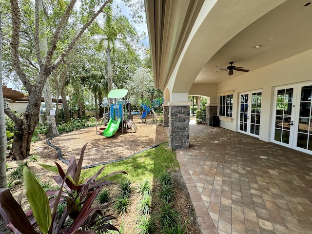 exterior space featuring a playground, ceiling fan, and french doors