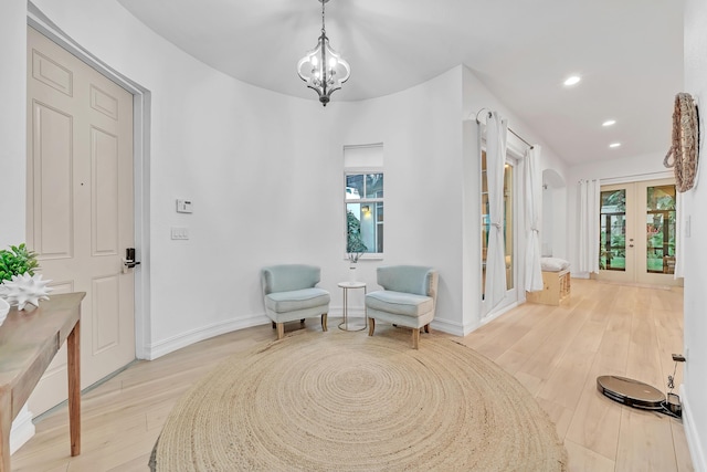 sitting room featuring a wealth of natural light, french doors, and light wood-type flooring