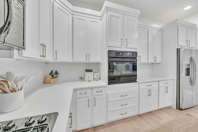 kitchen featuring white cabinetry, stainless steel fridge, and oven