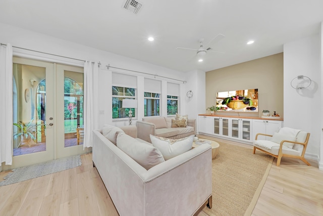 living room featuring french doors, light wood-type flooring, and ceiling fan